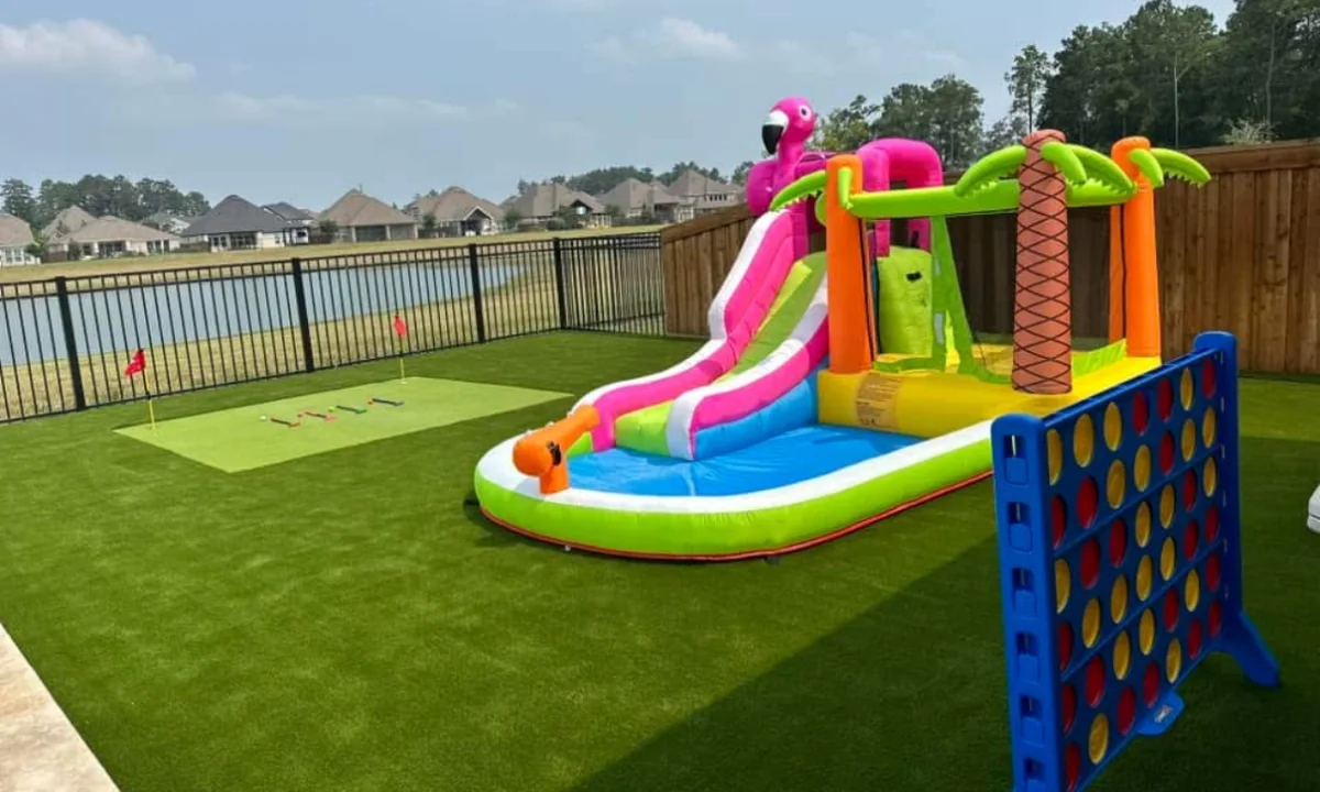 Backyard artificial turf with a putting green and a kids water slide