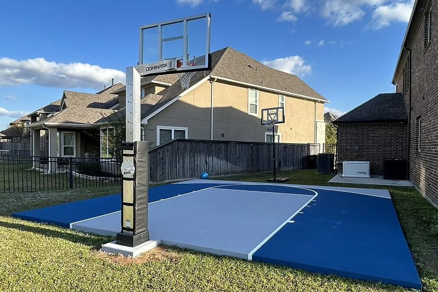 Blue and gray backyard basketball court with an adjustable hoop