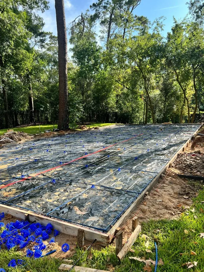 Excavated court area with wood forms, vapor barrier and blue rebar grid in place