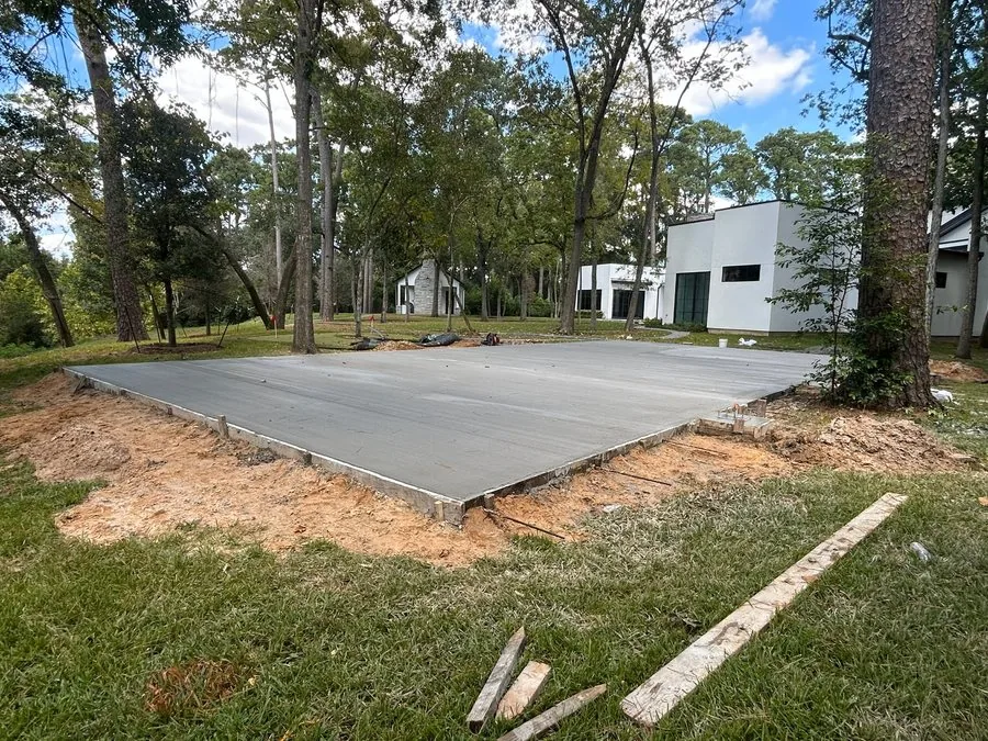Freshly poured and finished concrete court slab inside wood forms