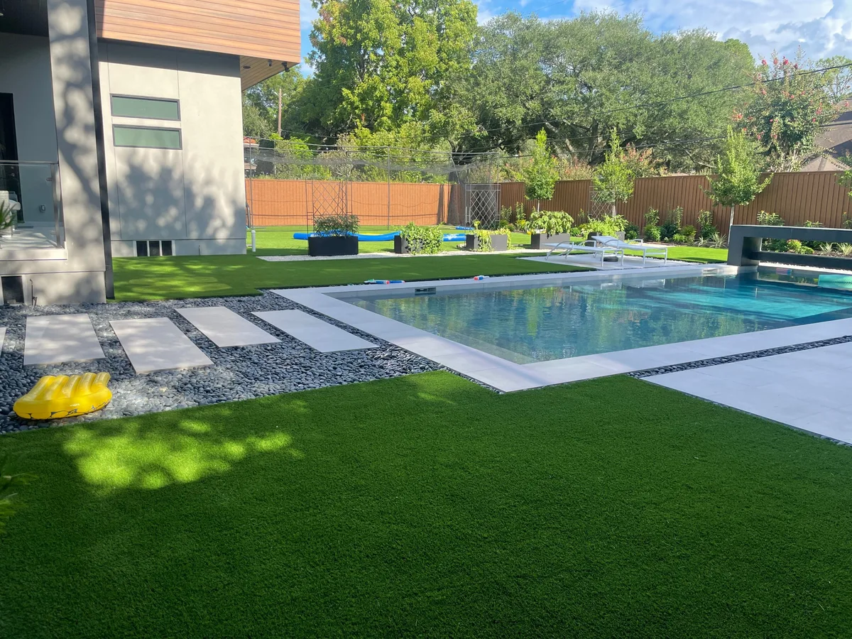 Modern backyard with artificial turf lawn, pool and stepping stone pavers